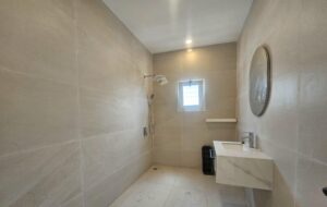 Salle de bain moderne avec douche à l'italienne et matériaux nobles dans une résidence de standing à Marcory